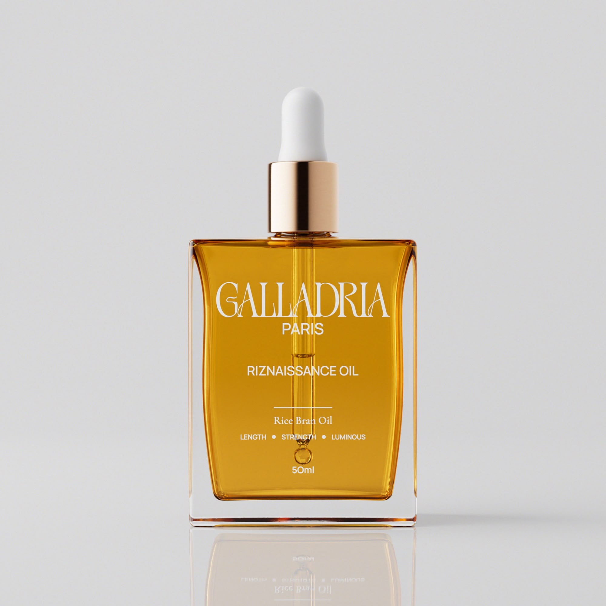 Flacon Riznaissance Oil de Galladria Paris, huile capillaire 50 ml avec pipette dorée, sur fond gris clair